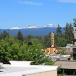 Downtown Bend rooftops with Tower Theater, Mt Bachelor and other mountains in the background.
