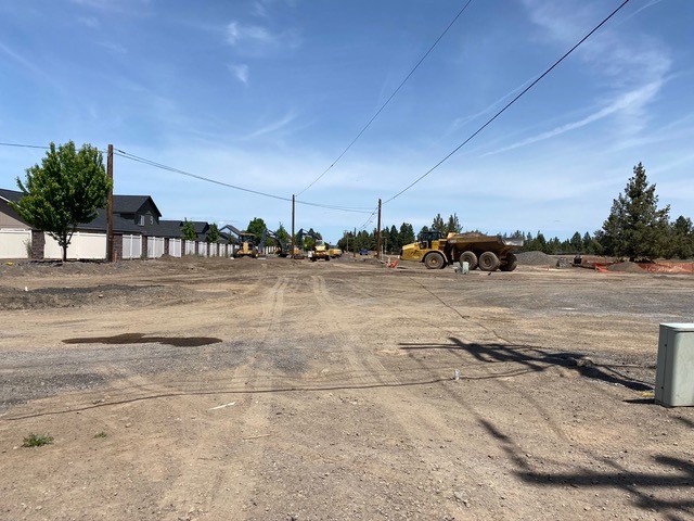 A photo of work crews and construction equipment continuing construction of the Deschutes Market Road & Butler Market Road roundabout.