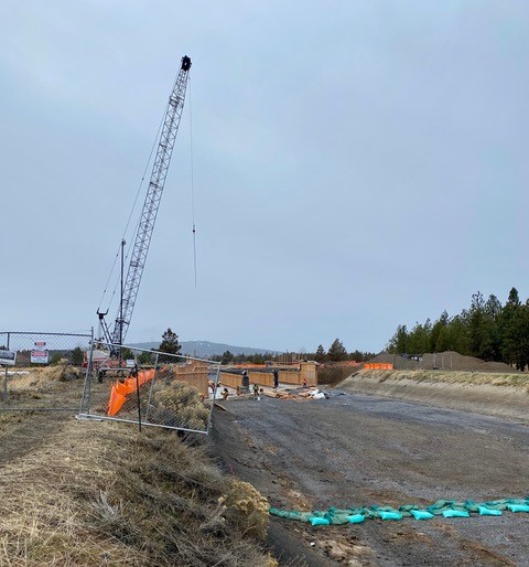 A photo of a construction crew and crane continuing structure work on the Empire Avenue crossing.