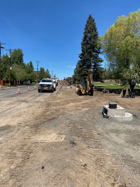 A photo of a new storm sewer maintenance hole and the widening of Purcell Blvd. There are cones and excavation equipment along the street.