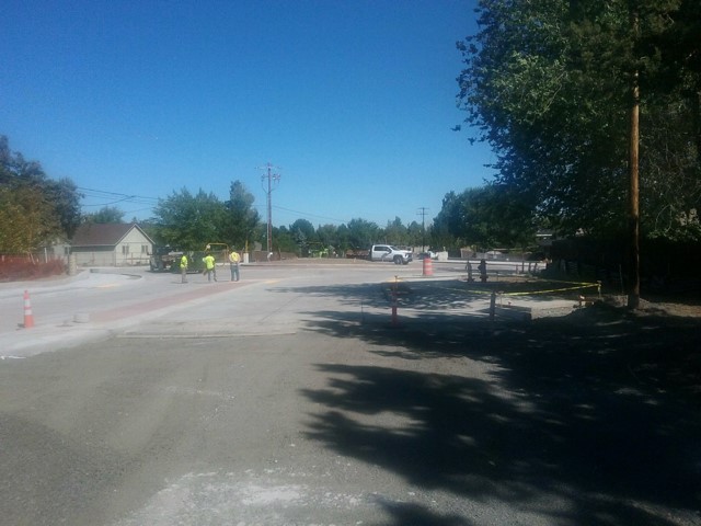 A photo of work crews performing prep work along NE Butler Market Rd facing east.