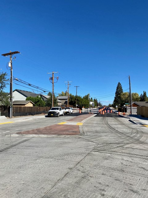 A photo of NE Purcell Blvd. facing north. There are cones, barricades, and road signs marking the road closure at the roundabout.