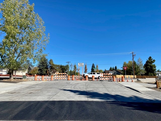A photo of the NE Purcell Blvd. & NE Butler Market Road roundabout. There are cones, barricades, and traffic signs marking the road closure at the roundabout.