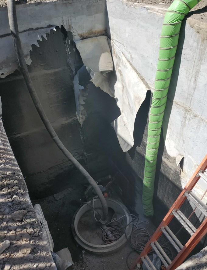A photo of a temporary pipe carrying sewage from the maintenance hole at Himler Creek Dr. the newly installed gravity sewer while the pump station was decommissioned.