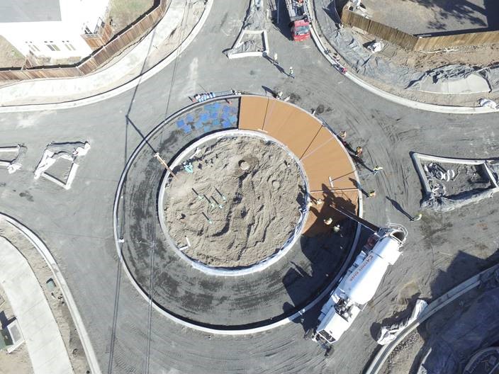 An aerial bird's-eye view of the work crew pouring colored concrete for the new roundabout.