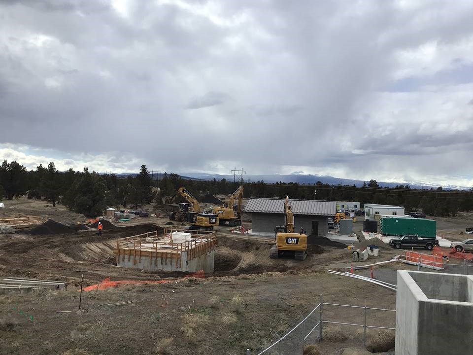 A photo of the wet well, electrical building, work crews, and excavation equipment on a construction site at the Water Reclamation Facility.