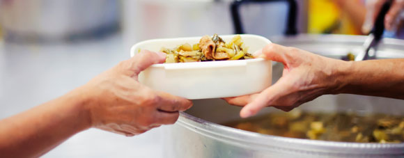 Someone serving someone else a bowl of food.
