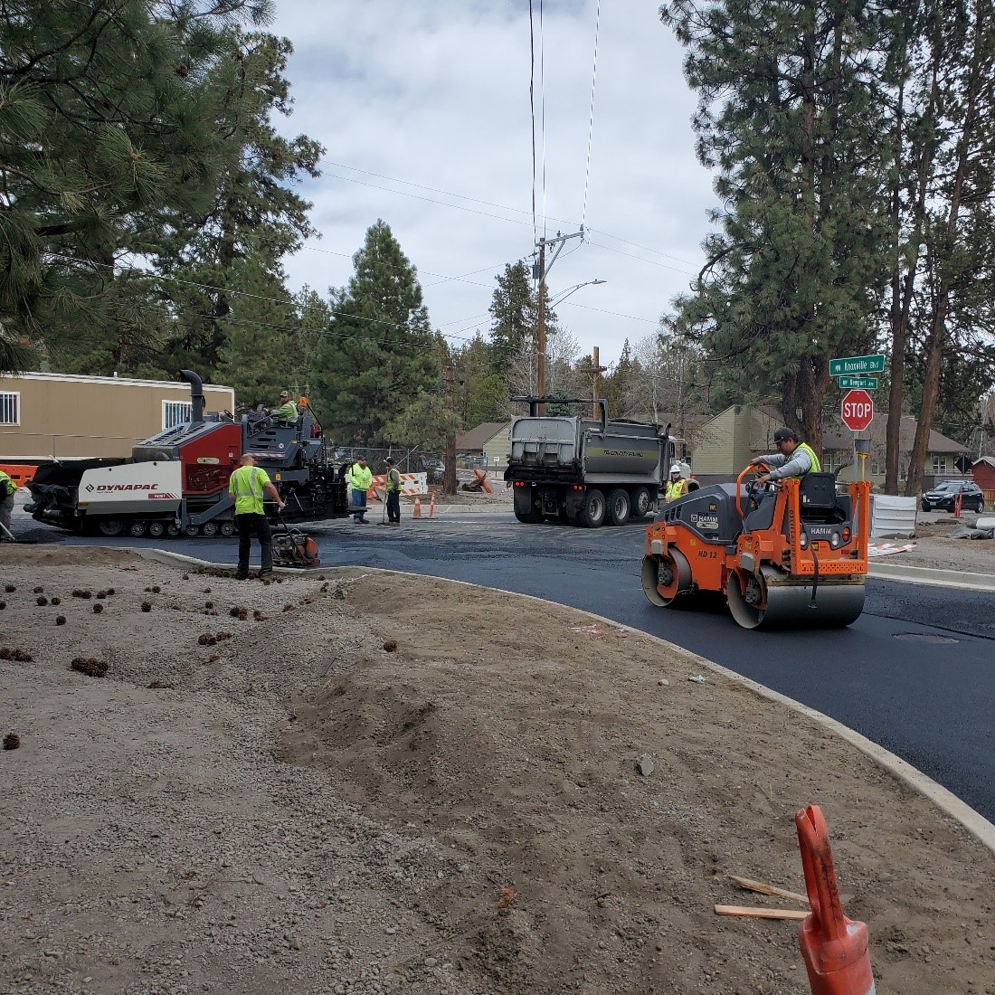 A photo of work crews using a roller and asphalt paver to lay asphalt along Knoxville Blvd.