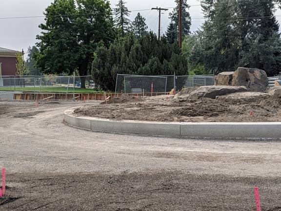A photo of the 9th St. & Newport Ave. roundabout with the original decorative boulders installed and the curb poured.