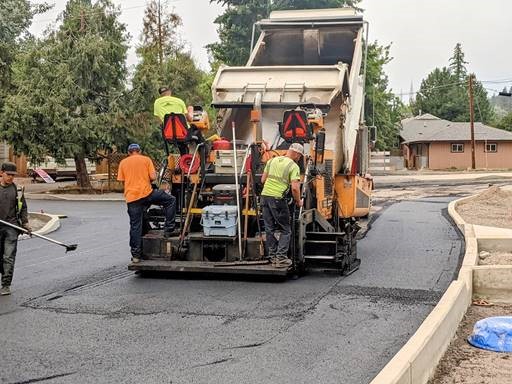 A photo of paving crews laying down the first layer of pavement at Federal St. and Nashville Ave.