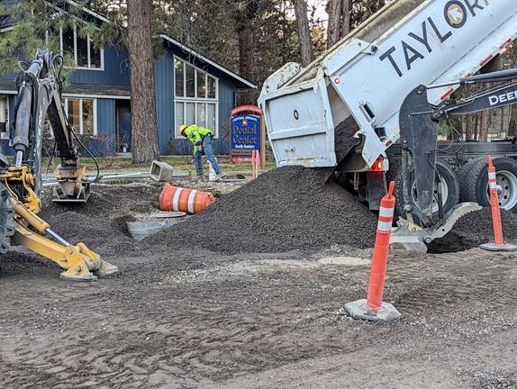 A photo of work crews using excavation equipment to backfill stormwater structures in preparation for aggregate sub-grade.