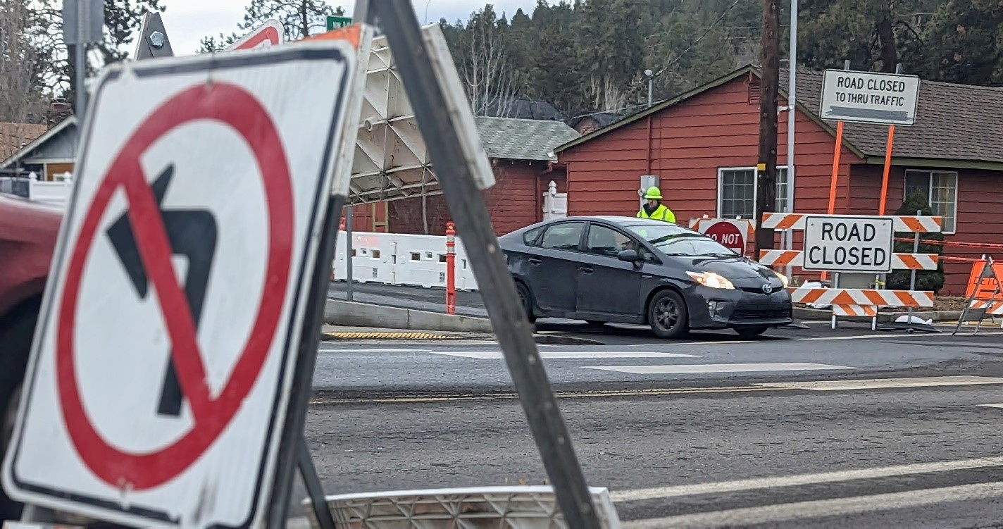 A photo of six road closure & traffic control signs and pedestrian channelizing devices installed on the westside of the Milwaukee Ave. & 14th St. intersection.