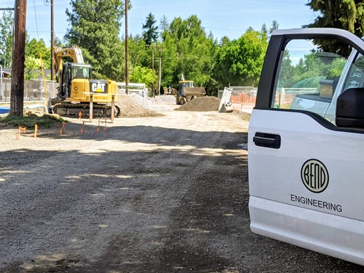 A photo of a City vehicle and excavation equipment onsite during an inspection and review of completed work.