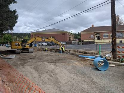 A photo of work crews and equipment completing a section of pipe near Highland (Kenwood) School.