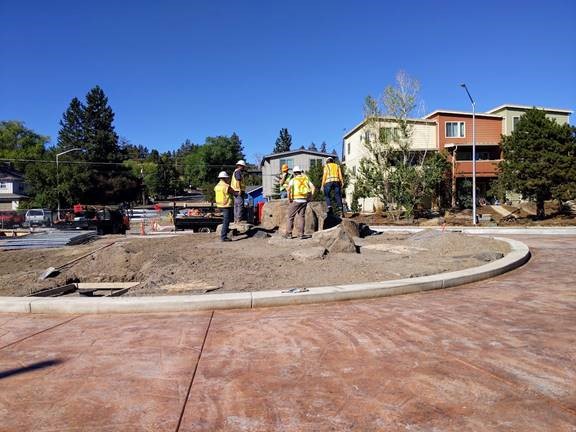 A photo of City of Bend staff members planning the re-installation of the 9th St roundabout art feature.