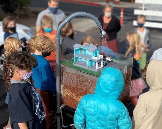 A photo of Highland Magnet School students observing an educational stormwater exhibit.