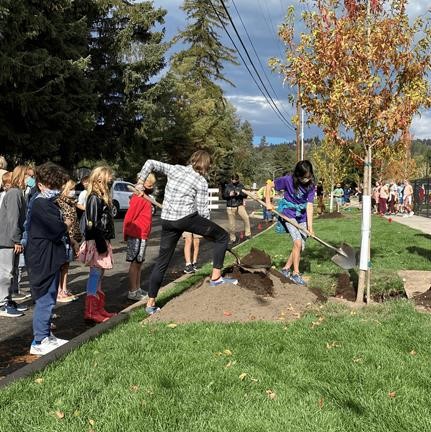 A photo of project team members and Highland Magnet School students planting trees.