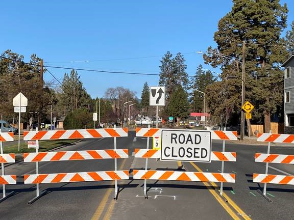 A photo of a barricade and 'ROAD CLOSED' sign at the closure of the 9th Street/Newport Avenue roundabout.