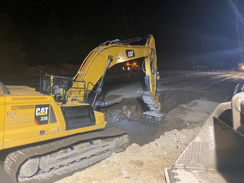 A photo of night work crews using a large hydraulic excavator to excavate east of  HWY 97.
