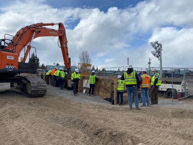 A photo project members and City Council wearing safety vests and hard hats and visiting the OR 97 crossing project site.