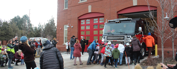 Kids pushing a new fire truck.