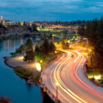 Trails of light from cars as they pass over Reed Market Bridge at night.
