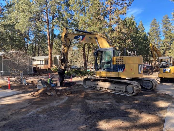 A photo of work crews and excavation equipment performing excavation work for new sewer services along McMullin Drive.