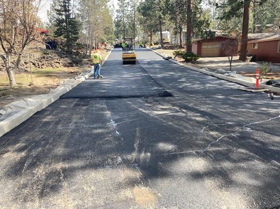 A photo of work crews paving along Cinder Lane, looking east.