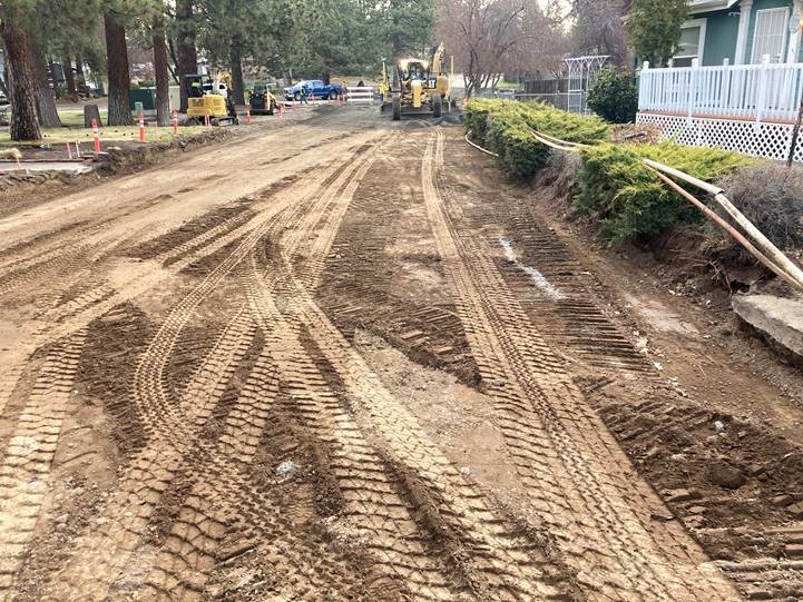 A photo of work crews using equipment for grade work along Mahogany Street to prep for curbs and asphalt paving.