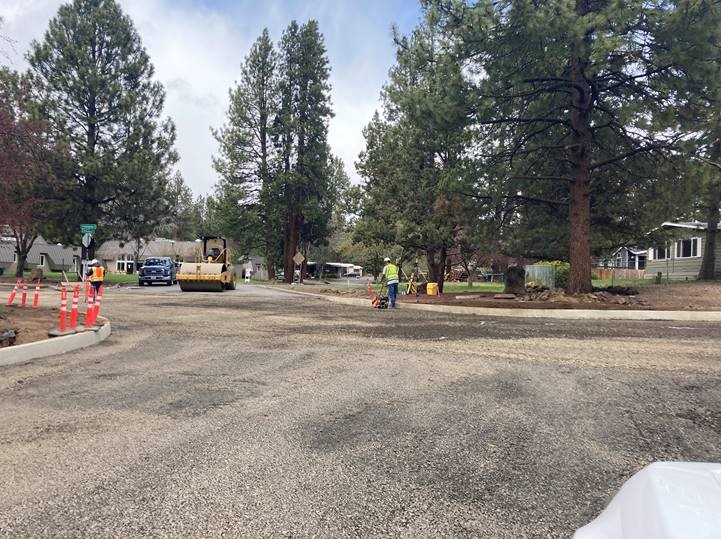 A photo of work crews performing compaction work along Mahogany Street to prep for asphalt pavement.