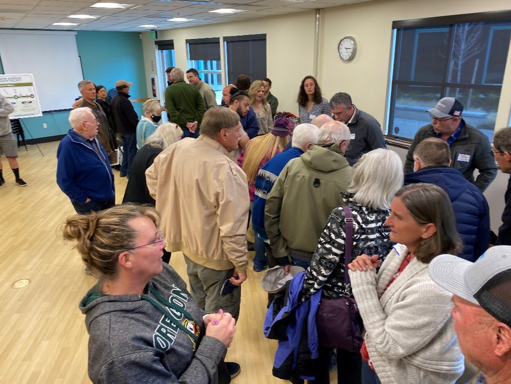 A photo of attendees conversing and viewing exhibits at the April 27 open house event for the Wilson Avenue Corridor Project.