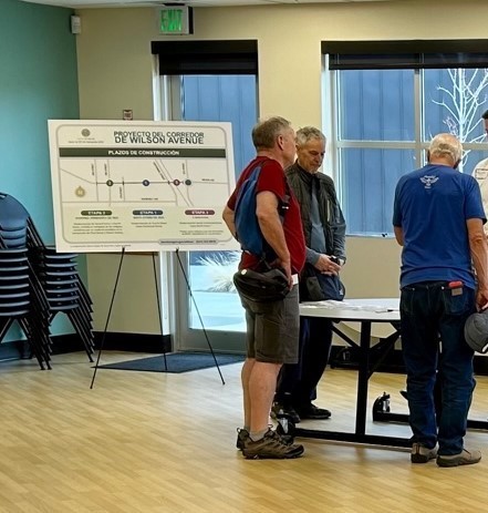 A photo of attendees looking at an exhibit on a table at the April 26 Phase 3 Informational Meeting.