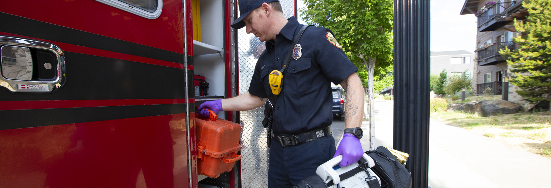 First responder loading equipment into the side of an ambulance.