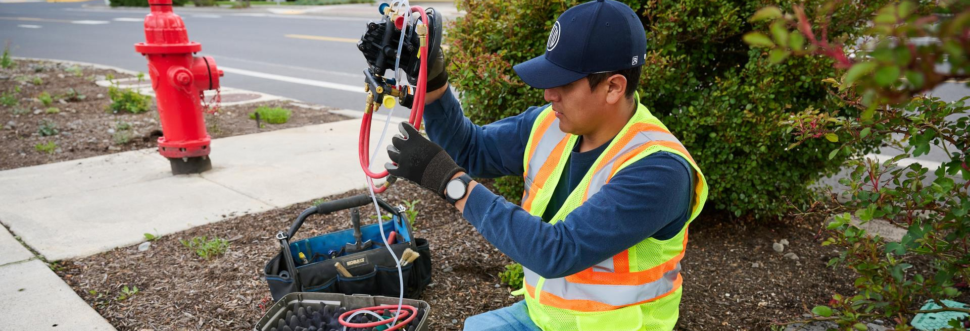 Worker installing a backflow device in an underground box.
