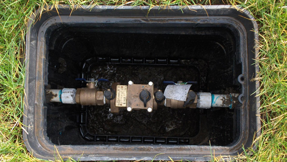 Backflow device in a water box in the ground.