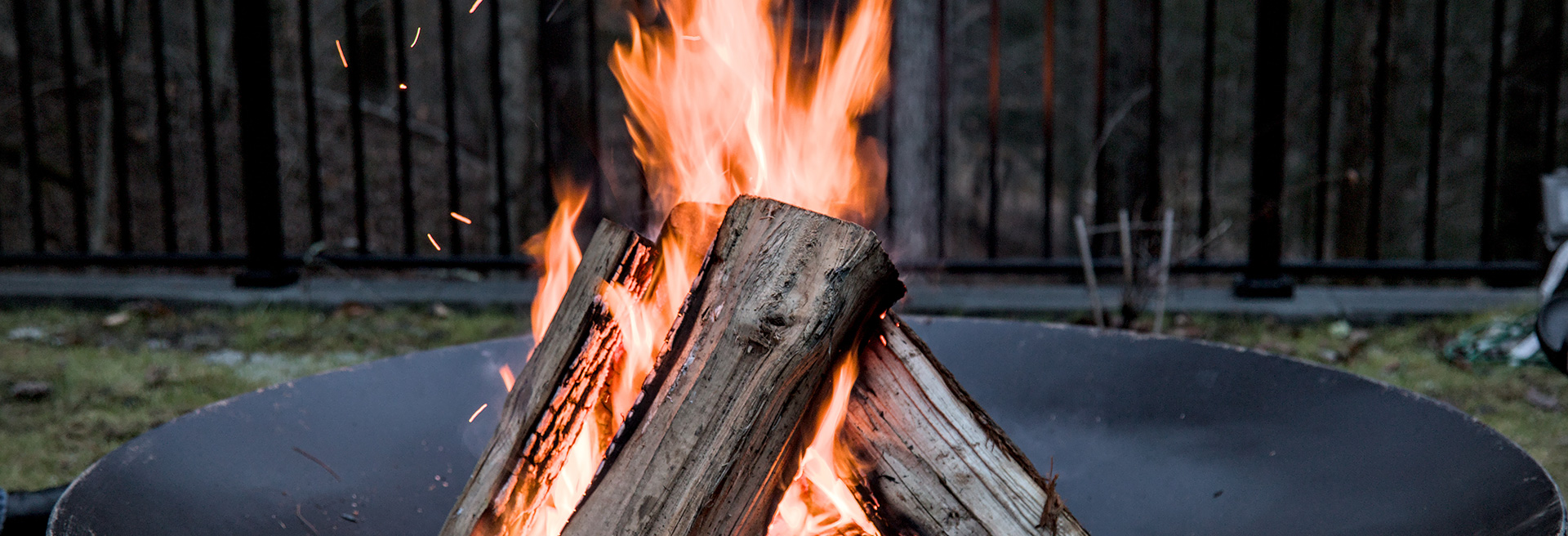 Firewood burning in a controlled fire pit.