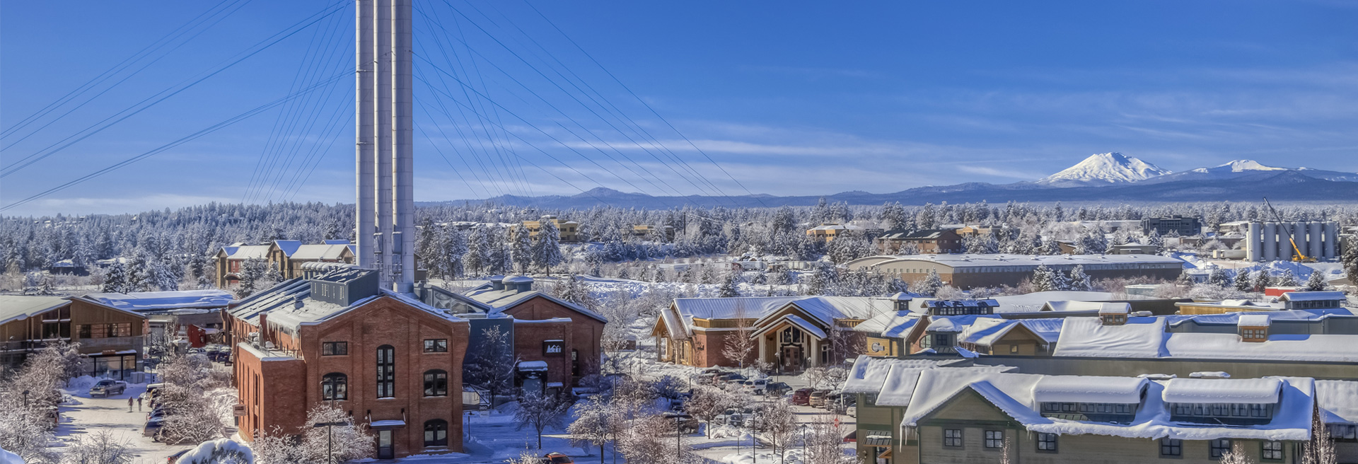 Old Mill District in Bend with snow in winter. Blue skies, fresh, white snow on buildings.