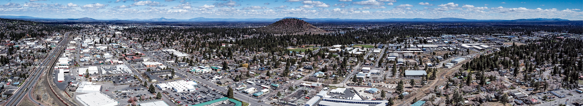 Image of the City of Bend looking east from the sky, Pilot Butte in the mid-ground.