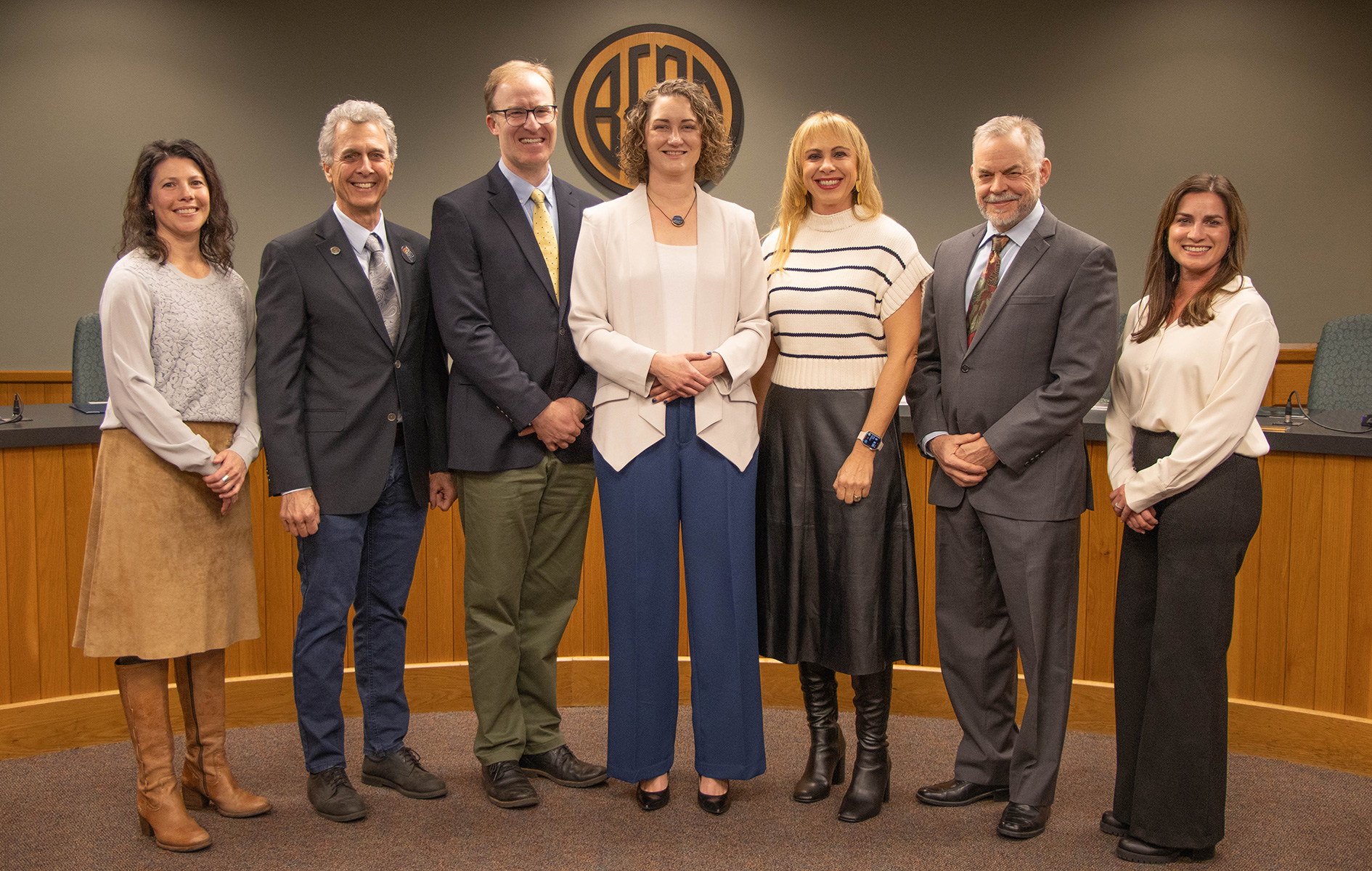 City Council members standing in front of the diesis in Council Chambers.
