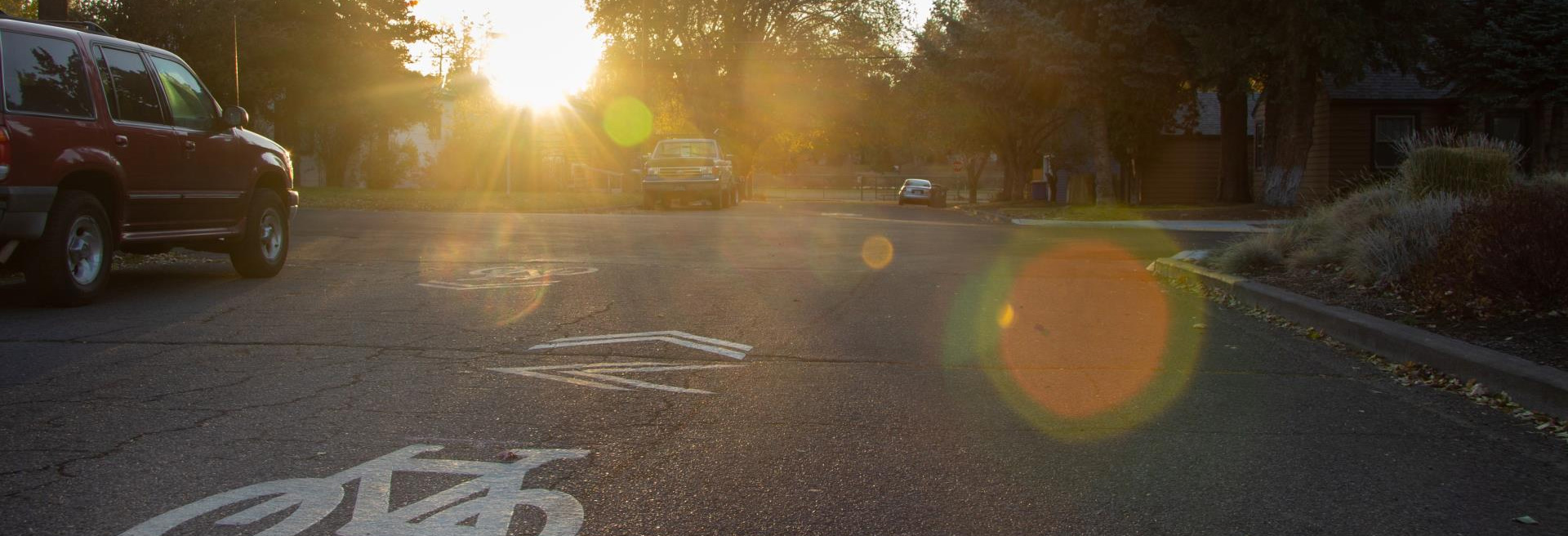 Street showing a bike plane with a red SUV driving next to the lane