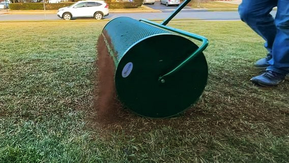 Composter spreading compost on a lawn.