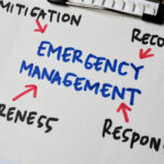 Emergency Management steps on a whiteboard in black, blue, and red text.