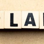 Black letters spelling 'Plan' on brown blocks.