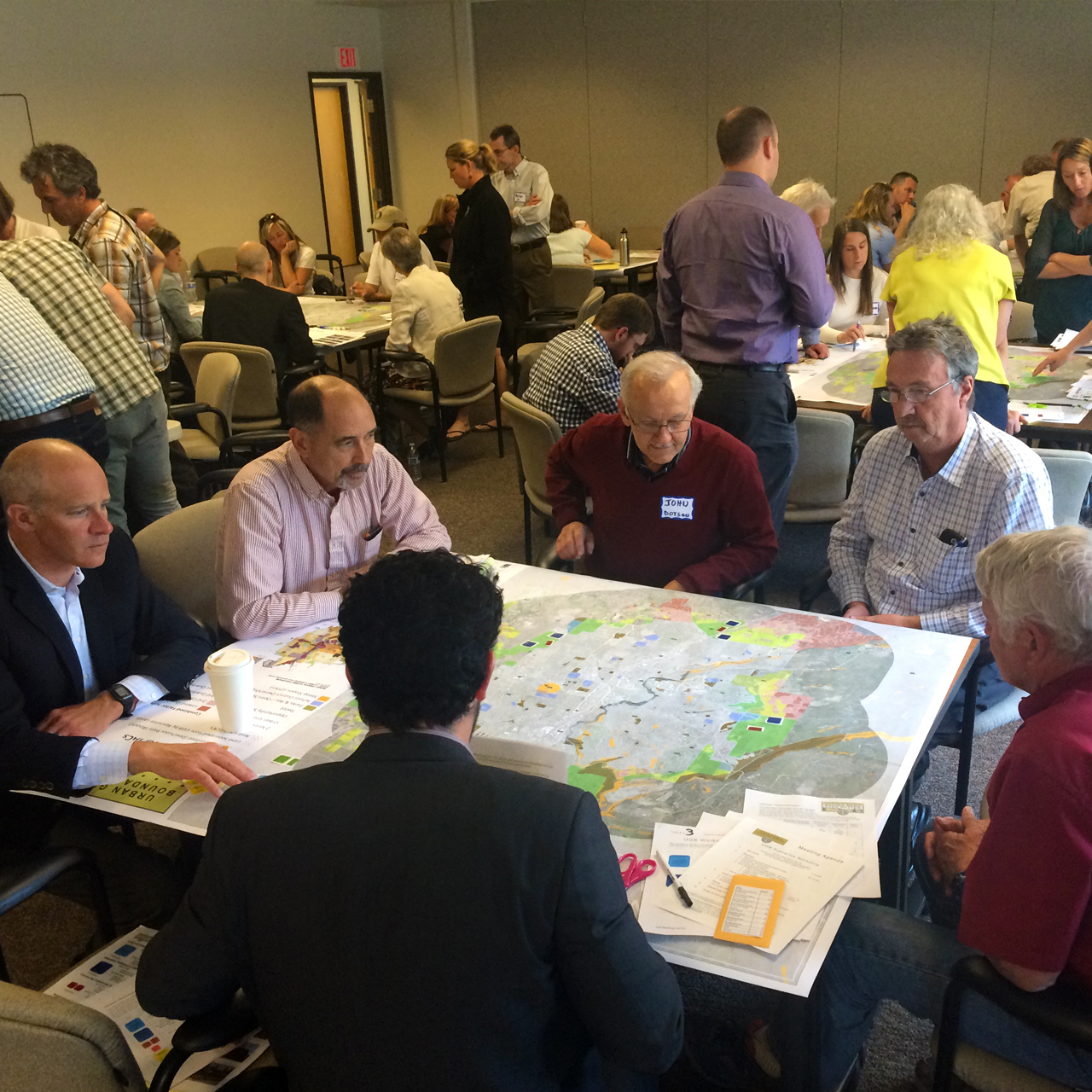 Committee members gathered around a table working on a map.