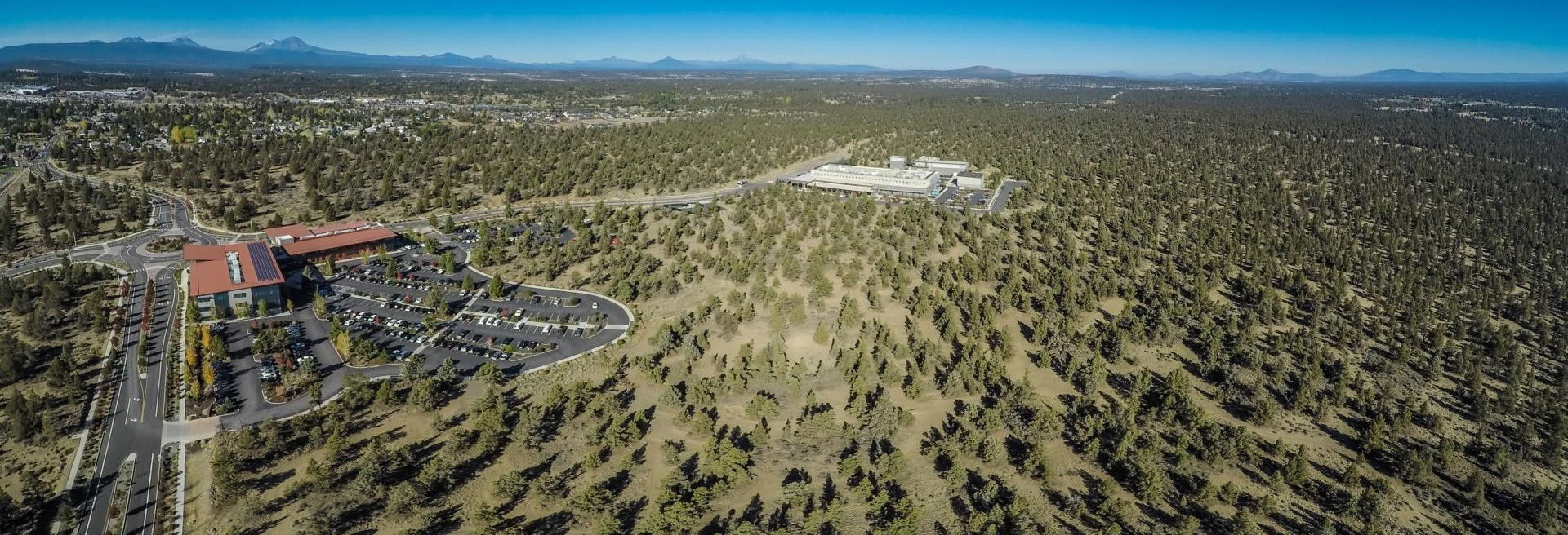 Drone shot of Juniper Ridge, largely open area with juniper trees and sagebrush. Blue skies.