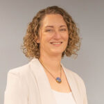 Melaine is of light complexion and has medium length light brown hair with highlights.