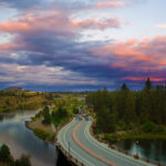 Southern Crossing Bridge over the Deschutes River looking east at sunrise. Clouds in the sky in deep red and purple tones.