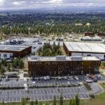 Drone shot of the Public Works campus with 4 buildings, Pilot Butte in the background.