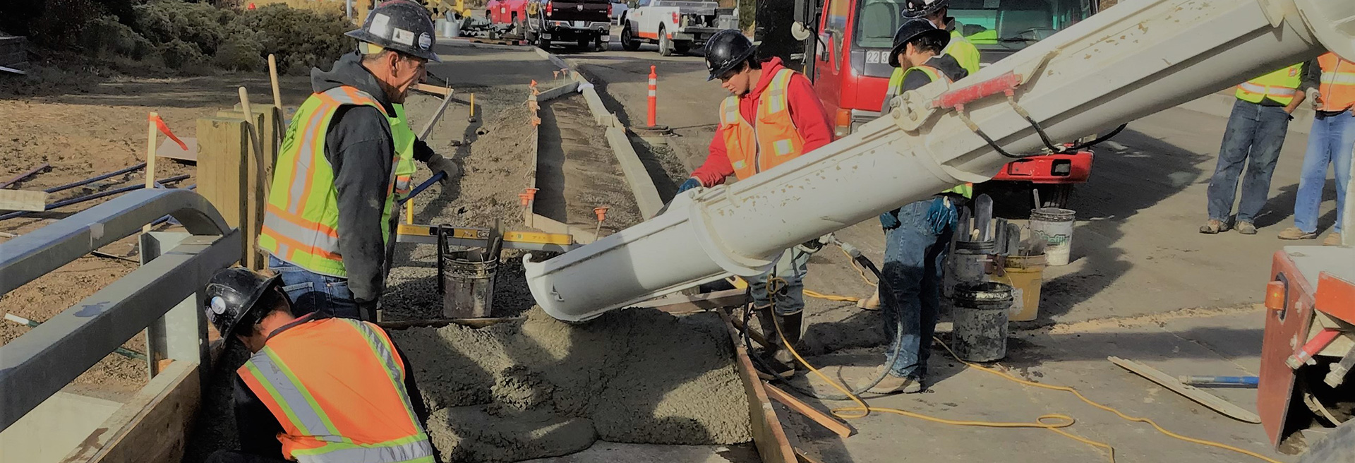 Construction workers pouring concrete for a sidewalk