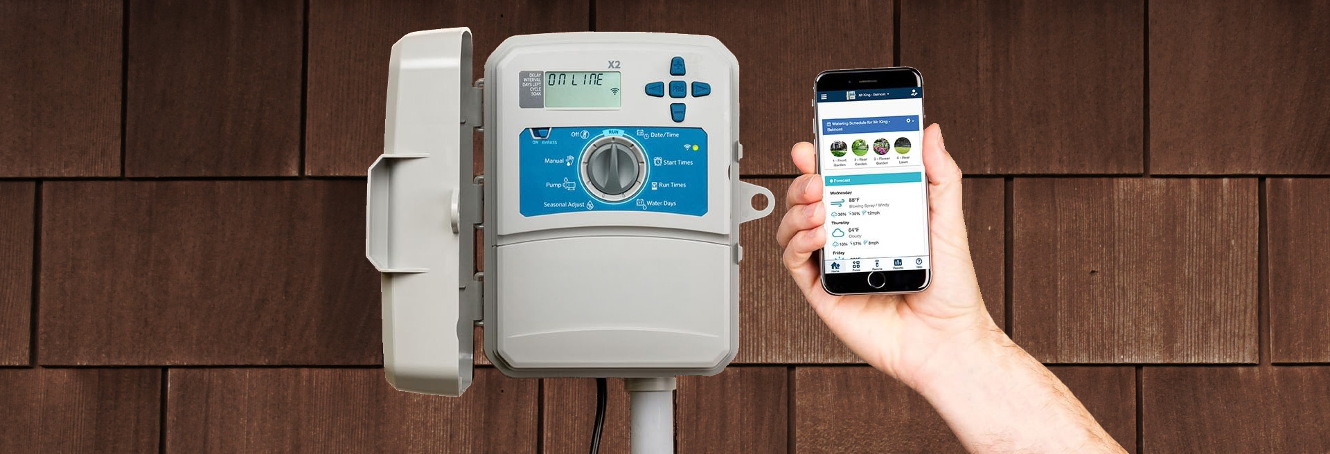Image of a brown shingle wall with a grey irrigation controller and hand holding up a smartphone with and irrigation app displayed on the phone.